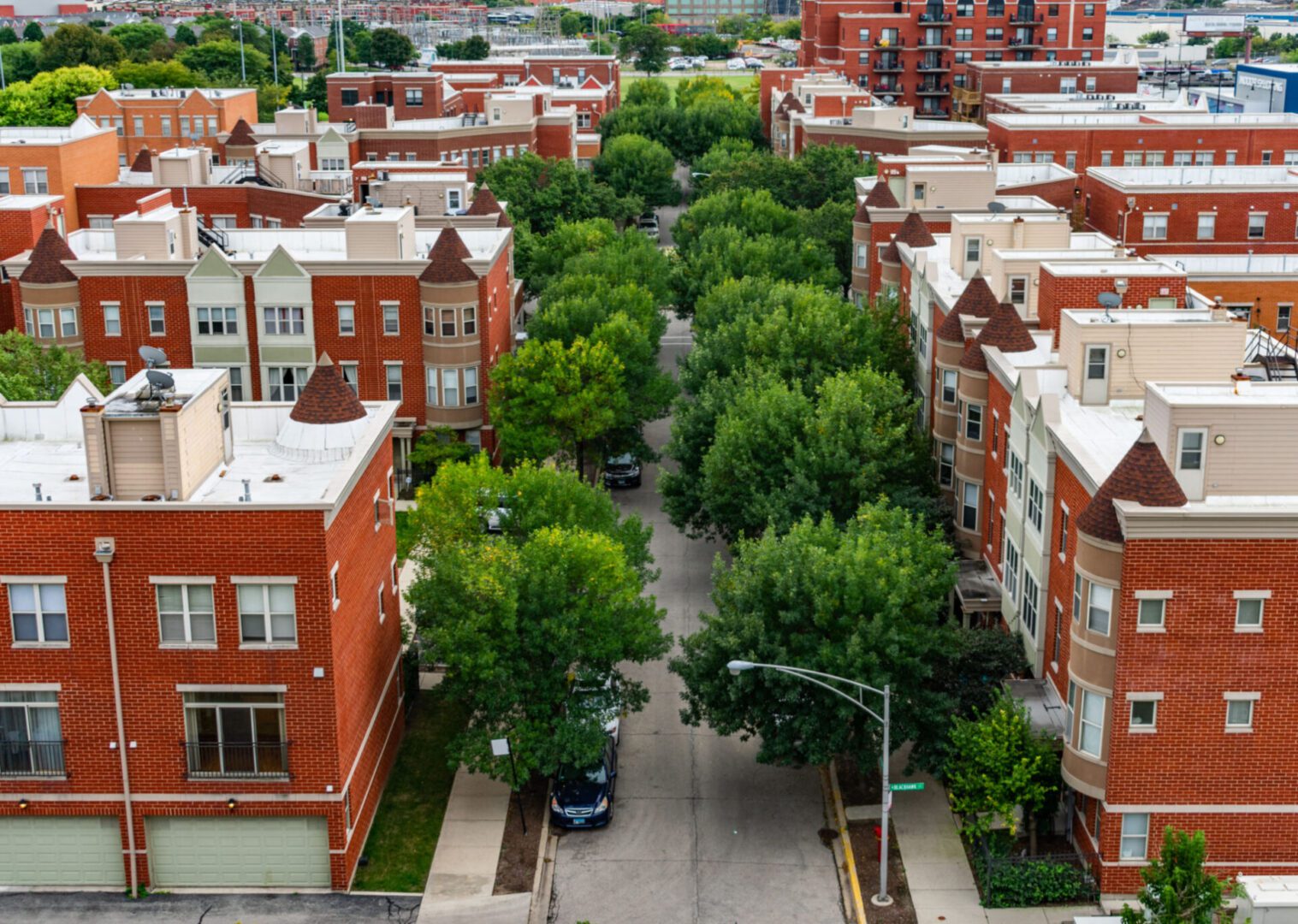 Red brick buildings with tree-lined street.