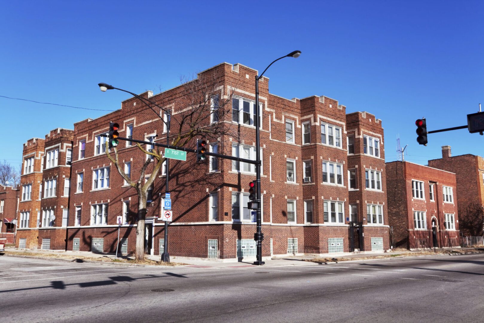 Red brick apartment building on street corner.